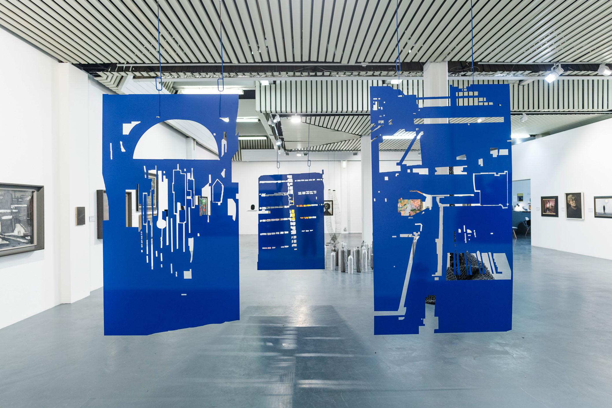 Semi-automatic machine self-portraits<br/>Self-portraits produced by a Trumpf punch machine. Hung on powder coating hooks. <br/>Mild steel sheet and powder coating.<br/> Largest panel 230 x 165 x 0.5 cm. 2019. <br/> Each panel is in an edition of 3. Installation at the Turnpike Gallery, Leigh UK. Works produced as part of Return to Ritherdon, a project based on a two-year artist placement at Ritherdon & Co Ltd, a manufacturer or steel enclosures based in Darwen Lancashire. Images by Livia Lazar. <br>Editions acquired by Arts Council Collection and Government Art Collection. 