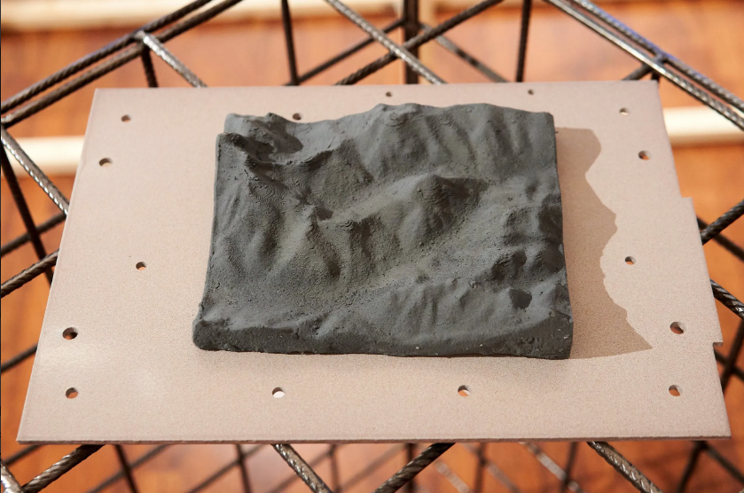 3D printed model of the mountain home of Cave del Predil - the former Lead and Zinc mining community in Udine, Friuli- Venezia Giulia, Italy. PETG and zinc powder.13cm x 16cm x 3cm <br><br> In the pittini closed material and zero waste policy means the zinc created as a by-product of the steel making process is captured and re-enters the manufacturing process - or the market - reducing the need to exploit natural sources of zinc.  <br><br>  Therefore, on a material level, Zinc is the link between the historical mining industry in Udine and the Pittini factory.  The digitally generated model is also a reference to the digitalization of making processes at Pittini, many of which monitor and reduce environmental impact.  <br><br> With thanks to Craig Oates for facilitating the 3D modelling process
